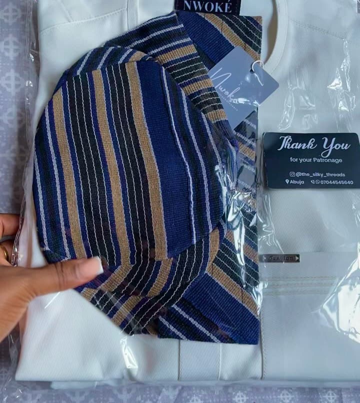 A finished NWOKÉ order folded in a clear bag with a thank-you card and a striped fila